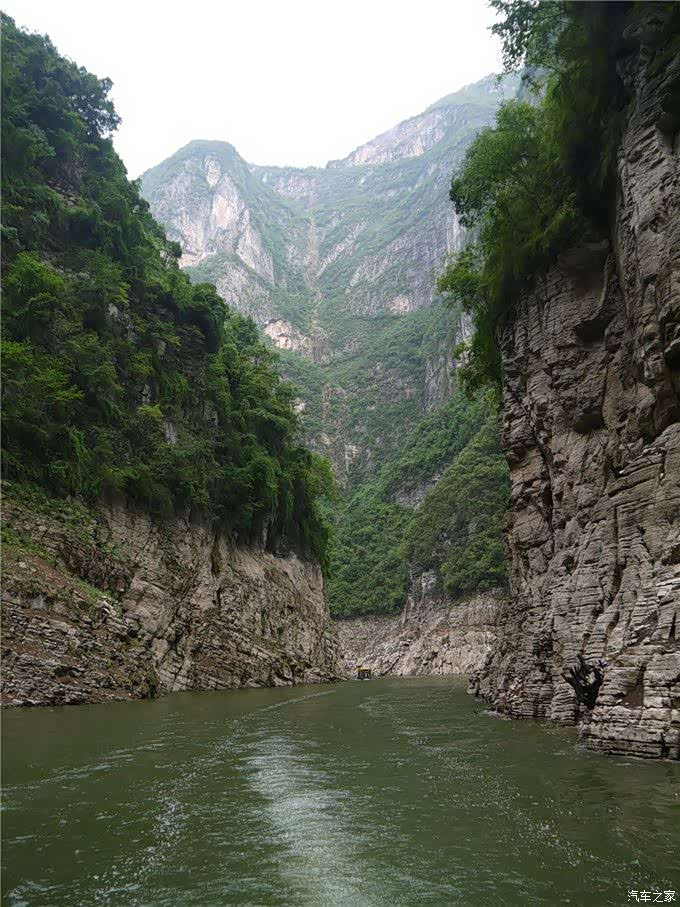 小船在大山间的小溪流行驶着