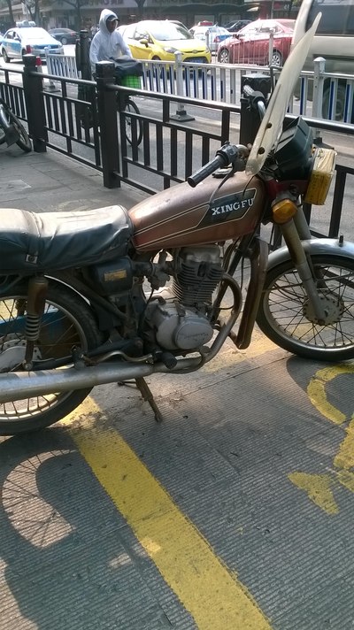 街边拍的幸福125,发动机上有honda字样,火花塞帽上有made in japan
